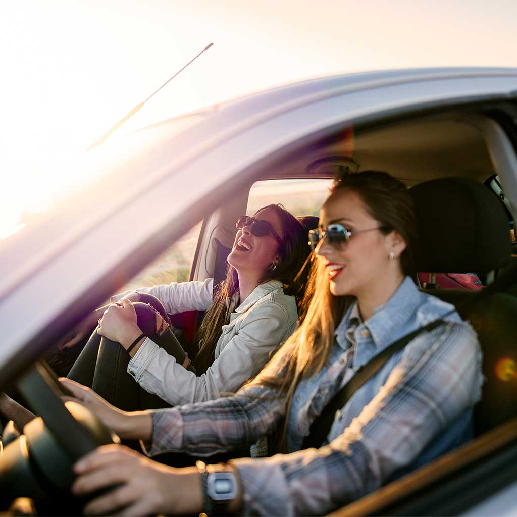 passenger and driver of a car enjoying a drive